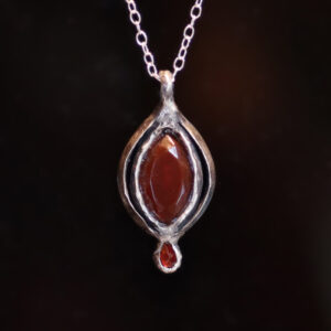 One of a kind side wound amulet in sterling silver with resin and garnet cabochon by Sword + Scythe