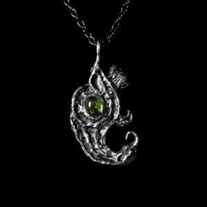 Astrological talismans of fixed star Vega featuring peridot set with savory and fumitory herbs, bird's nest, and vulture feather in solid sterling silver by Sword + Scythe