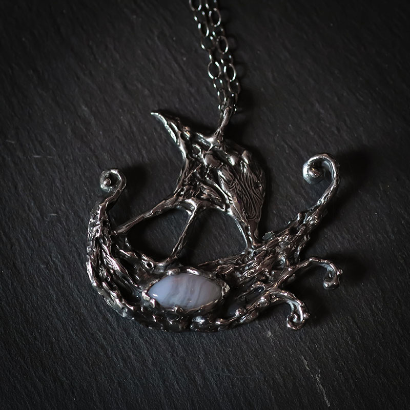 Astrological talismans of Argo Navis featuring blue lace agate above seaweed and 24k gold flake in sterling silver by Sword + Scythe