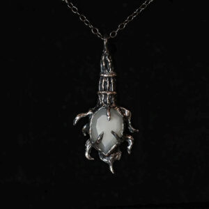 Ritual charm of Hekate featuring grey moonstone set over powdered yew in sterling silver by Sword + Scythe