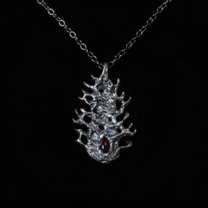 Astrological talismans of fixed star Aldebaran featuring garnet set with milk thistle seed and powdered cow’s eye in solid sterling silver by Sword + Scythe